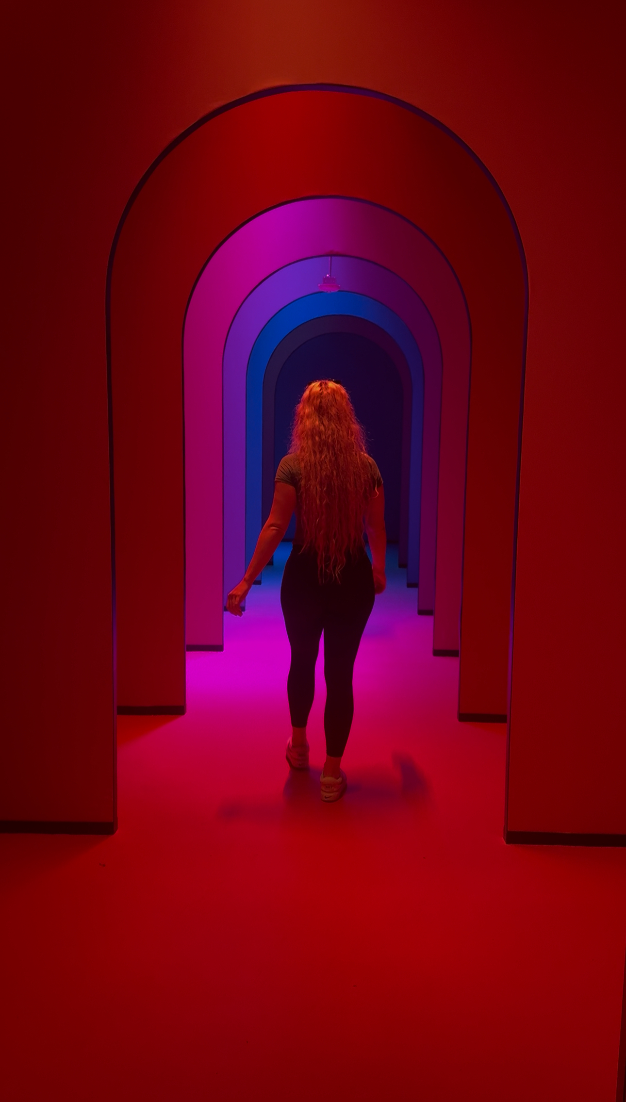 Hannah walking through neon arches